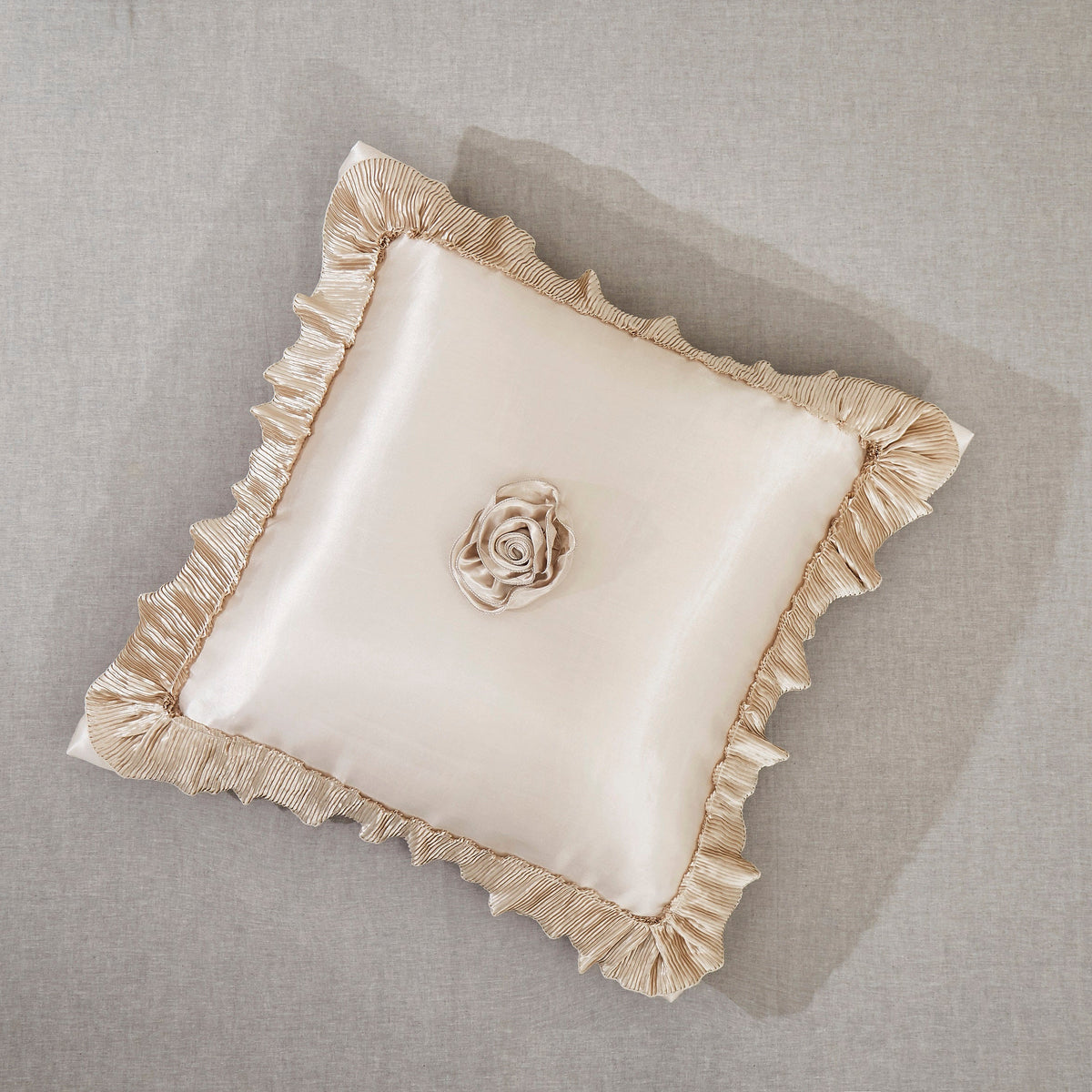 Cream beige satin euro sham with pleated ruffles and floral accents on a Victorian bed
