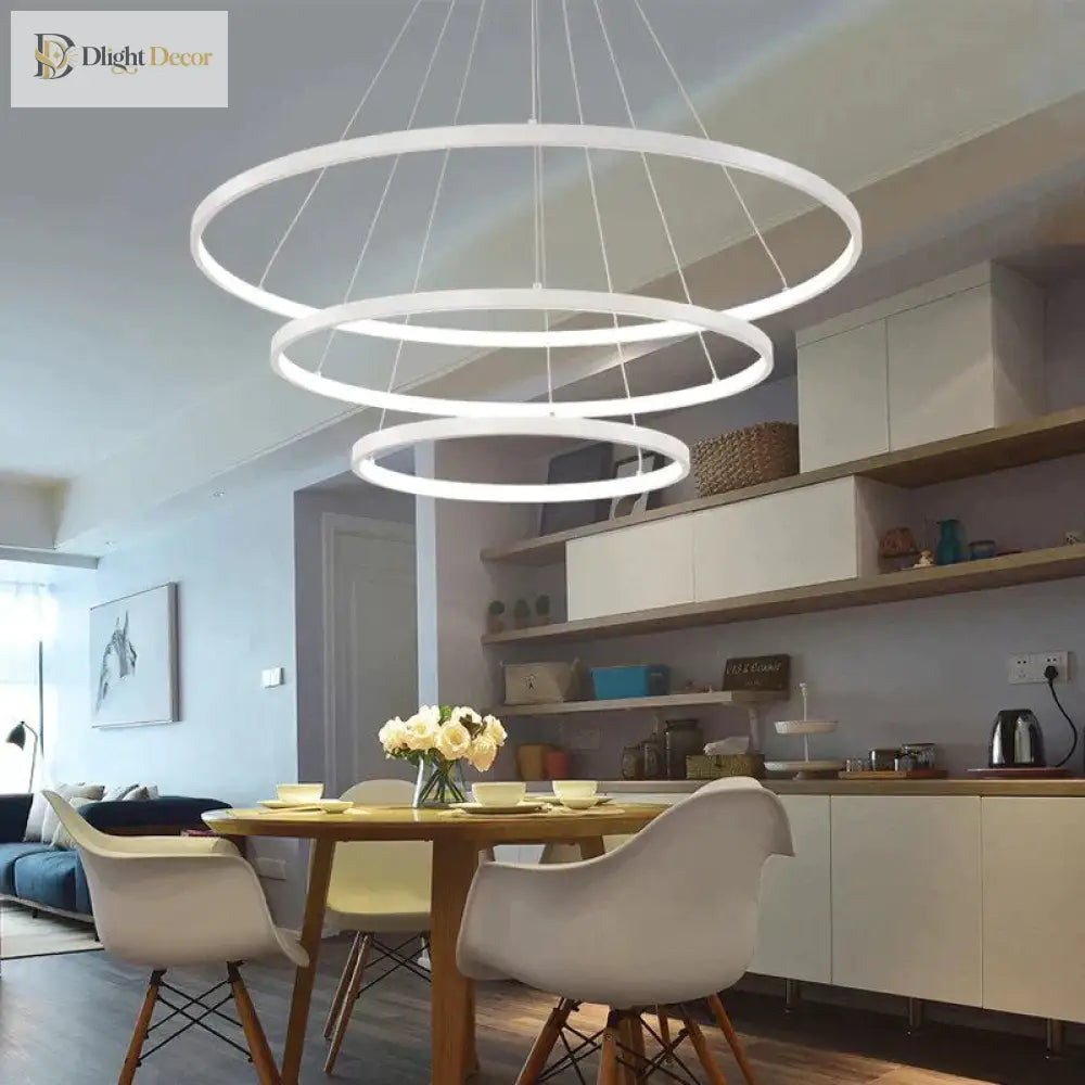 Cascading multi-ring LED chandelier in a golden finish hanging over a modern dining table