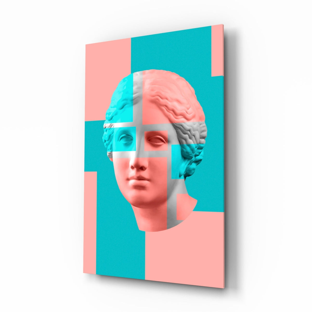 Pastel color block Venus bust glass wall art in coral pink and aqua hanging in a modern bedroom