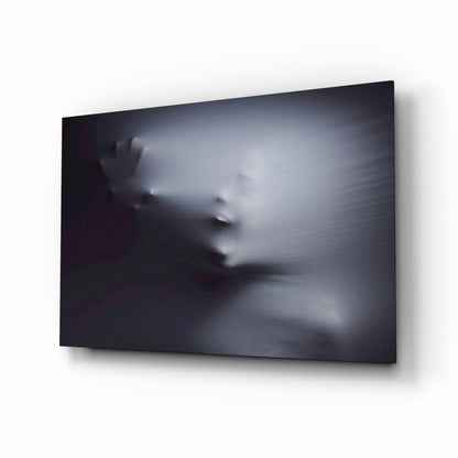 Ghostly face pressing through white fabric on black glass wall art in a media room